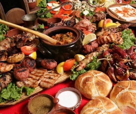 Bulgar Mutfağı Ve Geleneksel Lezzetlerin Keşfi Bulgar mutfağı, tarih boyunca farklı kültürlerin etkisi altında şekillenmiş zengin bir yemek geleneğine sahiptir. Osmanlı, Bizans ve Balkan kültürlerinin birleşimi, Bulgar mutfağını eşsiz kılan temel unsurlardan biridir. Bulgar yemekleri, genellikle taze sebze, yoğurt ve peynir gibi doğal ürünlerle hazırlanır. Sofralarda sıkça yer alan tarator ve banitsa, bu mutfağın en bilinen lezzetlerindendir. Tarator, soğuk yoğurt çorbası olarak yaz aylarında tercih edilirken, banitsa börek çeşidi olarak kahvaltıların vazgeçilmezidir. Konulu bir haber görseli.
