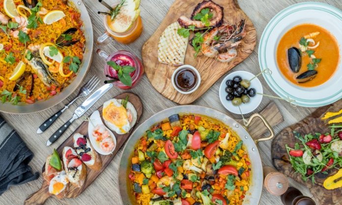 İspanyol mutfağı, Akdeniz ikliminin sunduğu bereketli tarım ürünleri ve tarih boyunca süregelen kültürel etkileşimlerle şekillenmiştir. Fenikelilerden Romalılara, Araplardan Yeni Dünya keşiflerine kadar uzanan süreç, mutfağın bugünkü zenginliğinin temelini oluşturur. Arap etkisi, özellikle baharatların, pirincin ve zeytinyağının mutfakta önemli bir yer edinmesini sağlamıştır. Konulu bir haber görseli.