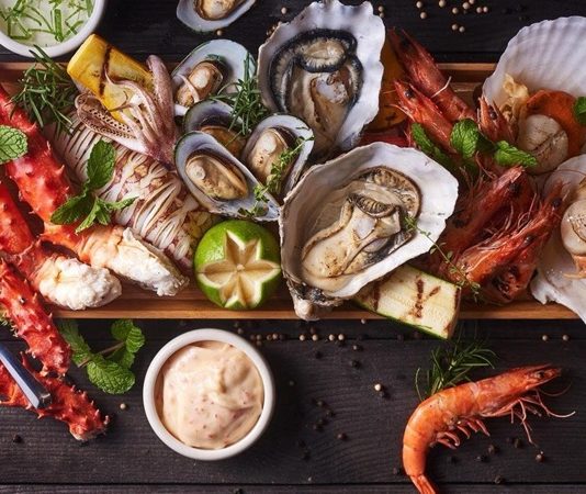 Denizden Sofraya Uzanan Lezzet Balık Restoranlarının Değişen Yüzü Balık restoranları, deniz kültürünün sofraya yansıyan en canlı örneklerinden biri olarak Türkiye’de hem geleneksel hem de modern anlayışla varlığını sürdürüyor. Kıyı şehirlerinden iç bölgelere kadar uzanan bu lezzet hattı, yalnızca yemek yenen mekânlar olmanın ötesinde bir yaşam tarzını ve sosyal buluşma kültürünü temsil ediyor. Günümüzde balık restoranları, taze ürün kullanımı, mevsimsellik ve sunum anlayışıyla gastronomi dünyasında ayrı bir konuma yerleşmiş durumda. Konulu bir haber görseli.