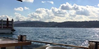 Denizle İç İçe Yaşamın Vazgeçilmezi Sahil Kafeleri Şehir hayatının yoğun temposu içinde denizle temas edilebilen nadir alanlardan biri olan sahil kafeleri, son yıllarda hem yerel halkın hem de ziyaretçilerin en çok tercih ettiği mekânlar arasında yer alıyor. Denizin sesi, açık hava ferahlığı ve manzara eşliğinde sunulan yeme içme deneyimi, sahil kafelerini sıradan kafelerden ayıran en önemli unsur olarak öne çıkıyor. Bu mekânlar, sadece bir şeyler içilen alanlar değil; aynı zamanda şehirden kaçışın en kolay yollarından biri hâline geliyor. Konulu bir haber görseli.