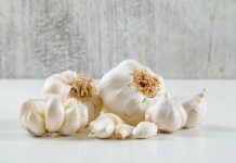 Mutfakların vazgeçilmez aromalarından biri olan sarımsak, yalnızca yemeklere kattığı yoğun lezzetle değil, aynı zamanda sağlık açısından sunduğu faydalarla da yüzyıllardır insan hayatında önemli bir yer tutuyor. Antik çağlardan bu yana kullanılan sarımsak, bugün modern mutfaklarda da hem geleneksel hem de yenilikçi tariflerin temel bileşenleri arasında bulunuyor. Çiğ, pişmiş, toz ya da sos formunda tüketilebilen sarımsak, dünya genelinde en çok tercih edilen doğal tatlandırıcılardan biri olarak öne çıkıyor. Konulu bir haber görseli.